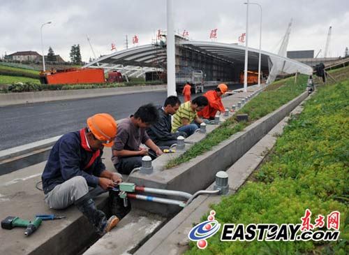 工人正在对道路两侧的雾灯进行安装调试