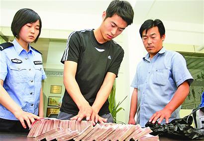 当着民警和的哥刘洪山的面,小王清点了自己遗失的四十万现金。