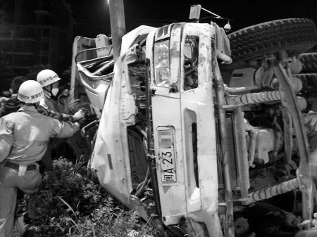 渣土车侧翻于安全岛中间的绿化带上,电线杆嵌入了渣土车的驾驶室内